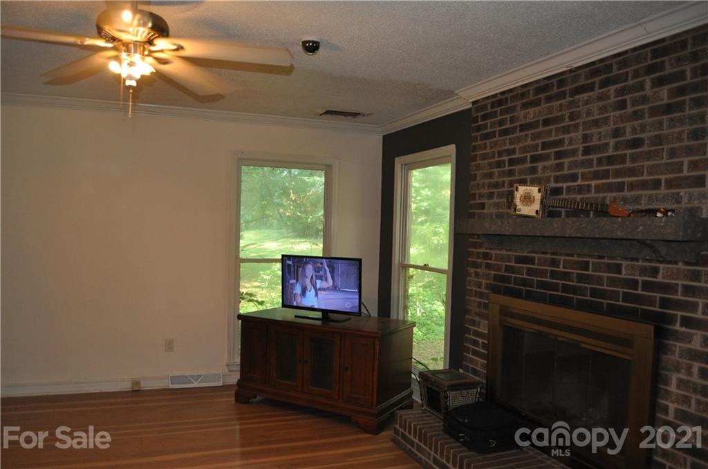 10024 Fireside Lane Charlotte, NC 28215 - Photo 8 of 18 a living room with furniture a flat screen tv and a fireplace
