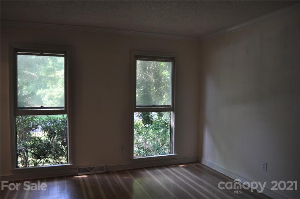10024 Fireside Lane Charlotte, NC 28215 - Photo 10 of 18 a view of an empty room with wooden floor and a window