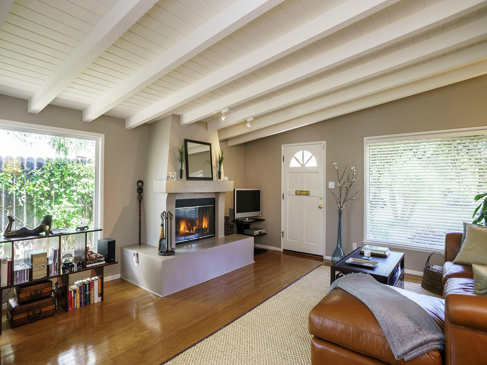 a living room with furniture large window and a fireplace