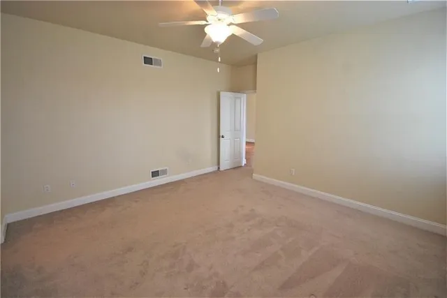 an empty room with a fan and a window