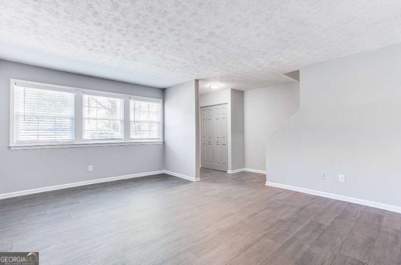 707 Franklin Road, Unit 613 Marietta, GA 30067 - Photo 2 of 13 an empty room with wooden floor and windows