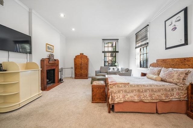 a spacious bedroom with a bed and a flat screen tv