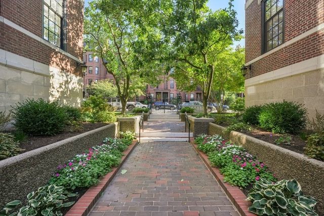 a view of house with garden and a large tree