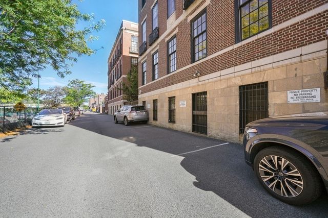 a view of a cars park in front of a building