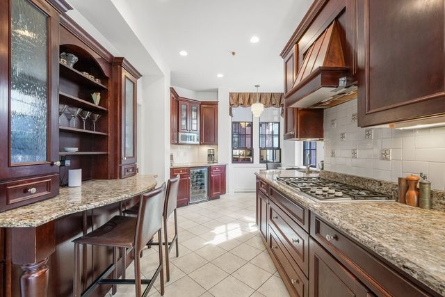a kitchen with stainless steel appliances granite countertop a stove a sink a dining table and chairs