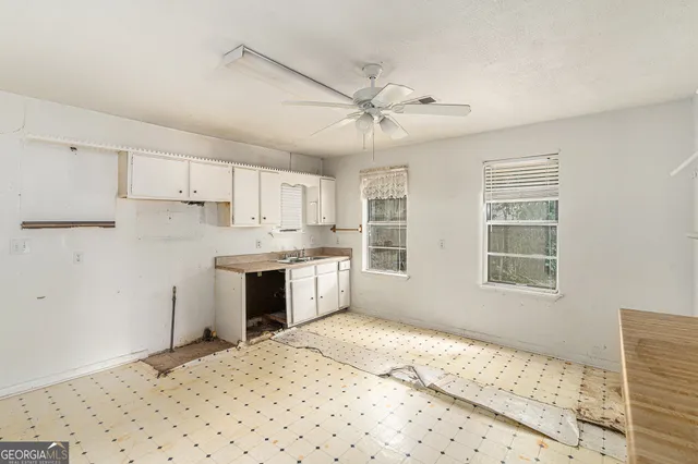 a kitchen with granite countertop white cabinets and white appliances