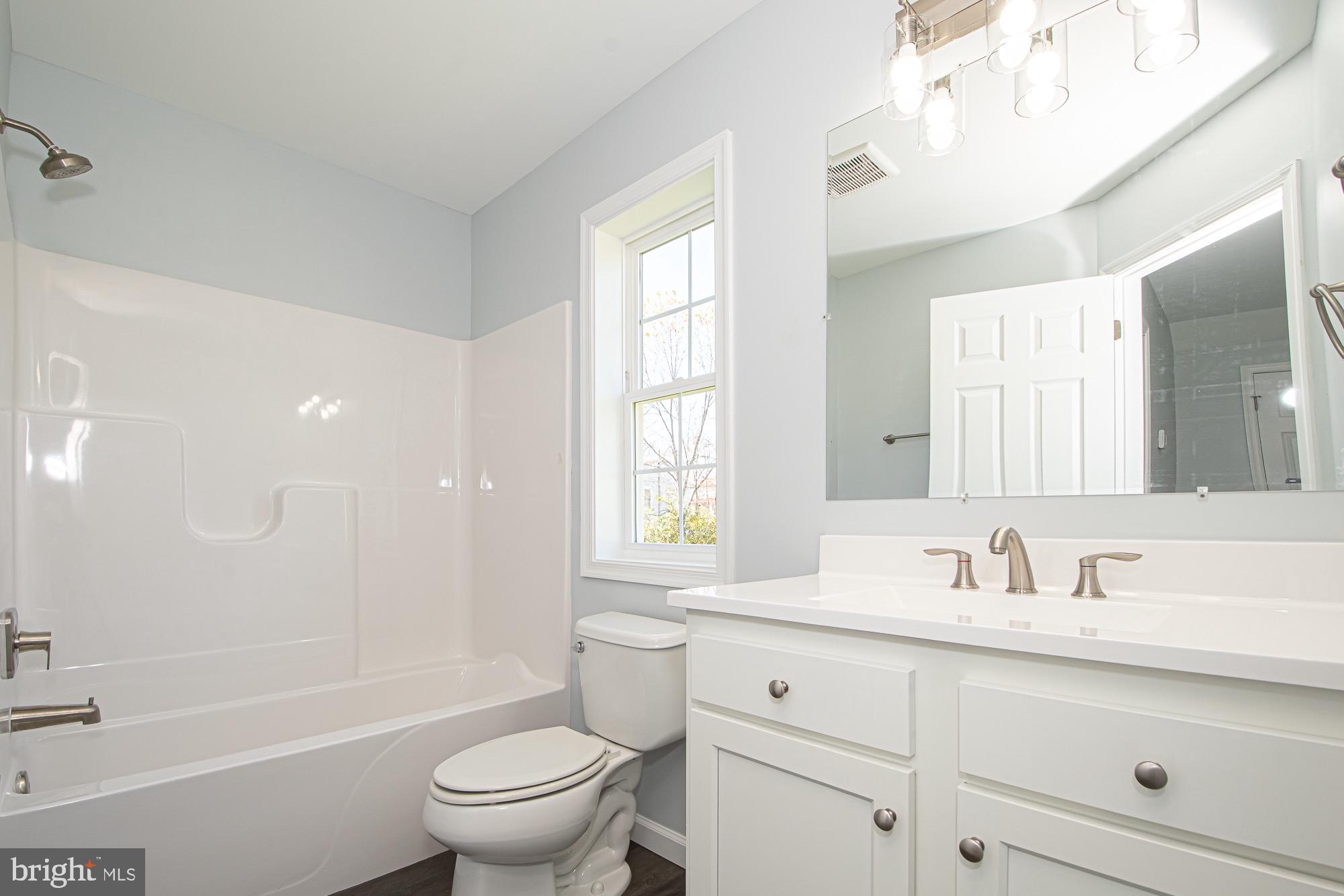 709 Ross Street Winchester, VA 22601 - Photo 22 of 40 a bathroom with a sink a toilet a mirror and a bathtub