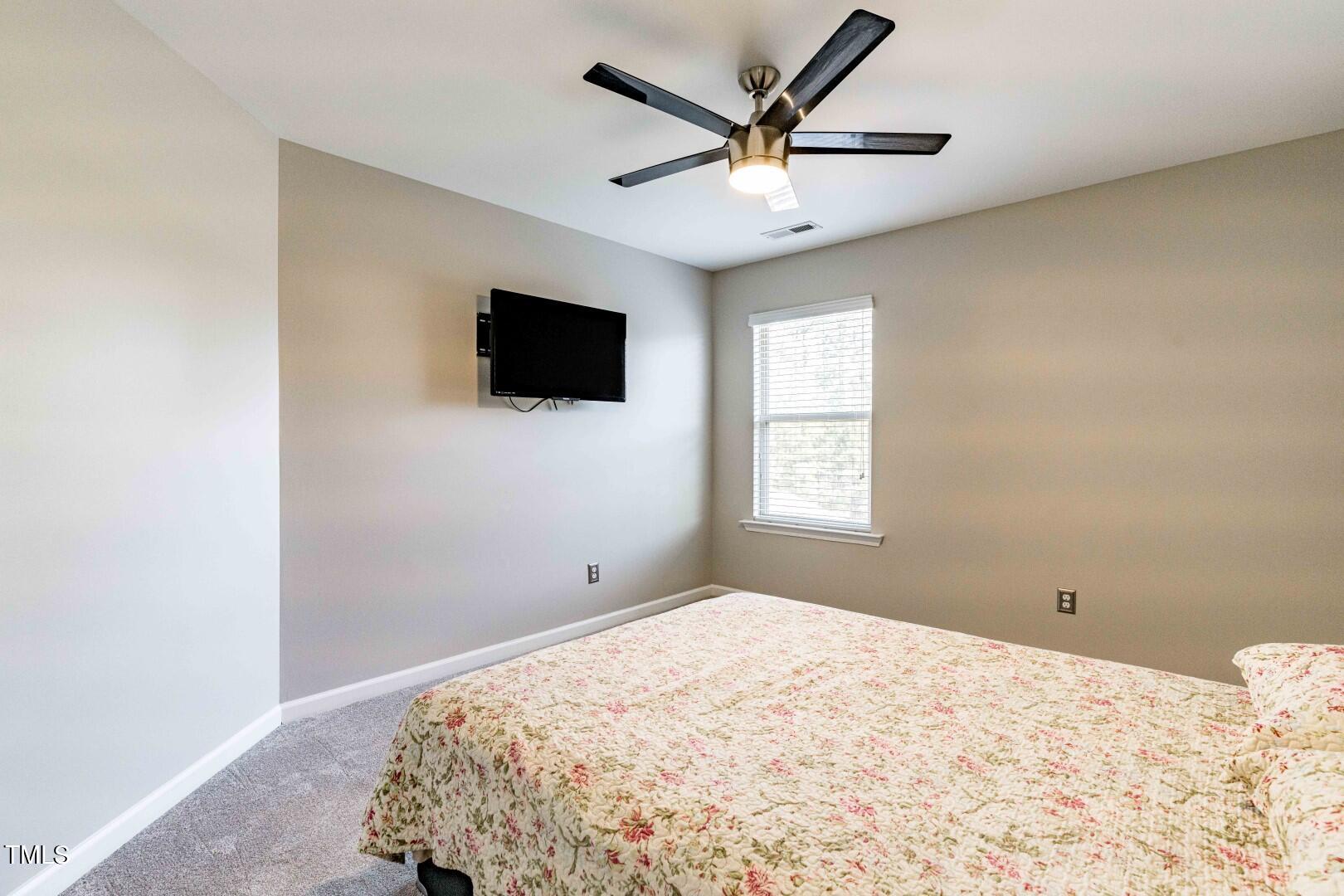 1017 Lakeview Road Durham, NC 27712 - Photo 23 of 32 a bedroom with a large bed and a flat screen tv