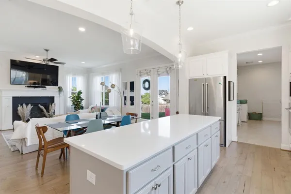 a large living room with stainless steel appliances kitchen island a fireplace furniture a flat screen tv and a kitchen view