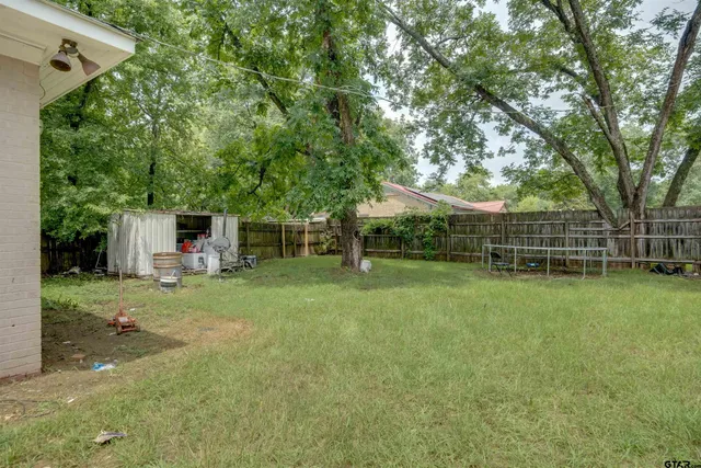 a view of a backyard with table and chairs and potted plants