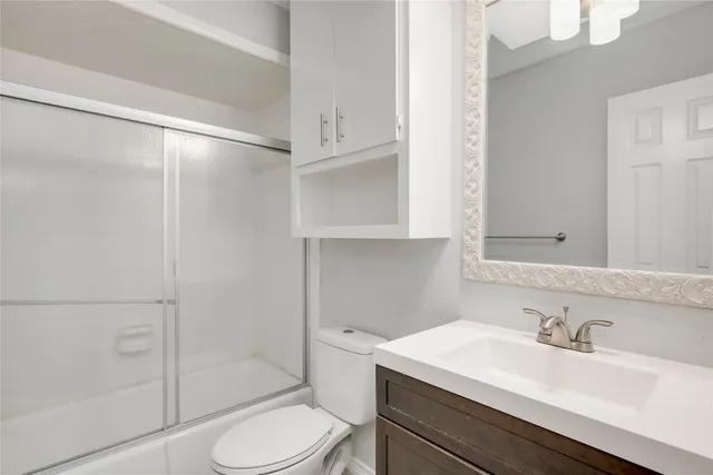 a bathroom with a sink toilet vanity and shower