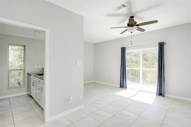 an empty room with closet and a ceiling fan