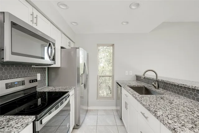 a kitchen with stainless steel appliances a stove a microwave and cabinets
