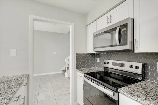 a bathroom with a granite countertop sink a toilet and a mirror