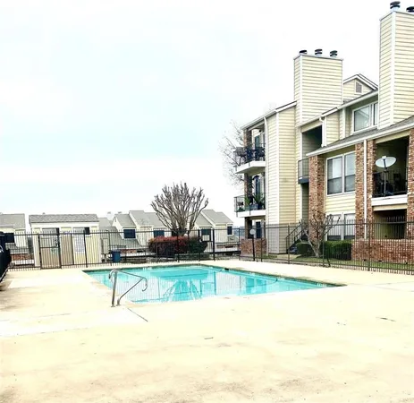 a view of a swimming pool with a lawn chairs and plants