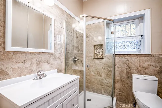 a bathroom with a sink a toilet and shower