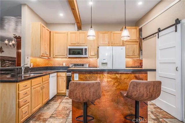 a kitchen with stainless steel appliances granite countertop a sink and a refrigerator