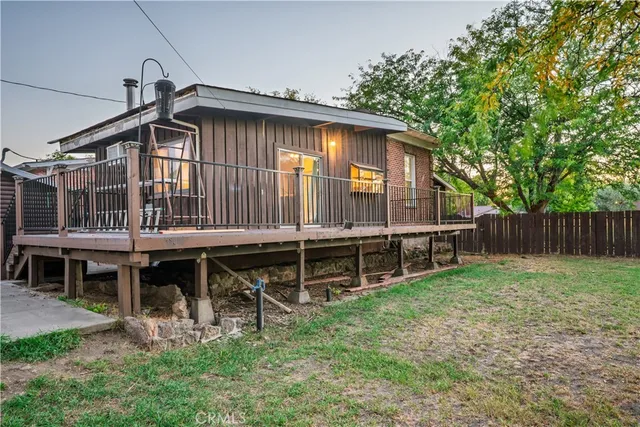 a backyard of a house with wooden deck and furniture