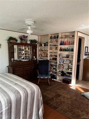 a bedroom with a bed a dresser and book shelf