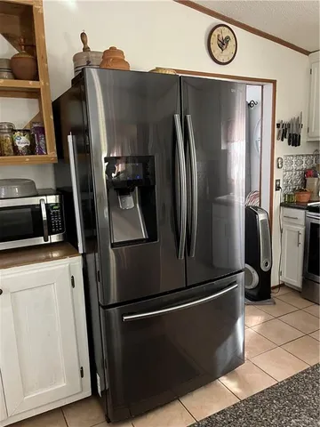 a metallic refrigerator freezer sitting in a kitchen