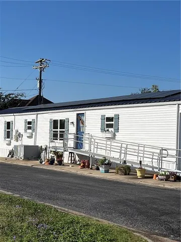 a front view of a house with yard and parking