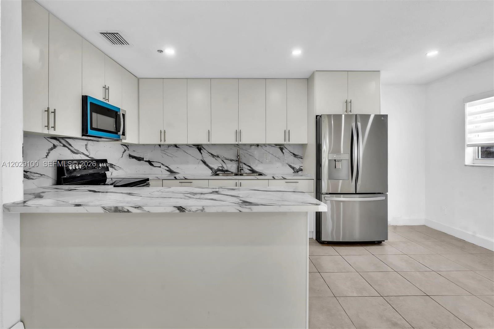 11790 Southwest 34th Street Miami, FL 33175 - Photo 21 of 56 a kitchen with stainless steel appliances granite countertop a refrigerator a stove a sink a microwave a refrigerator and white cabinets