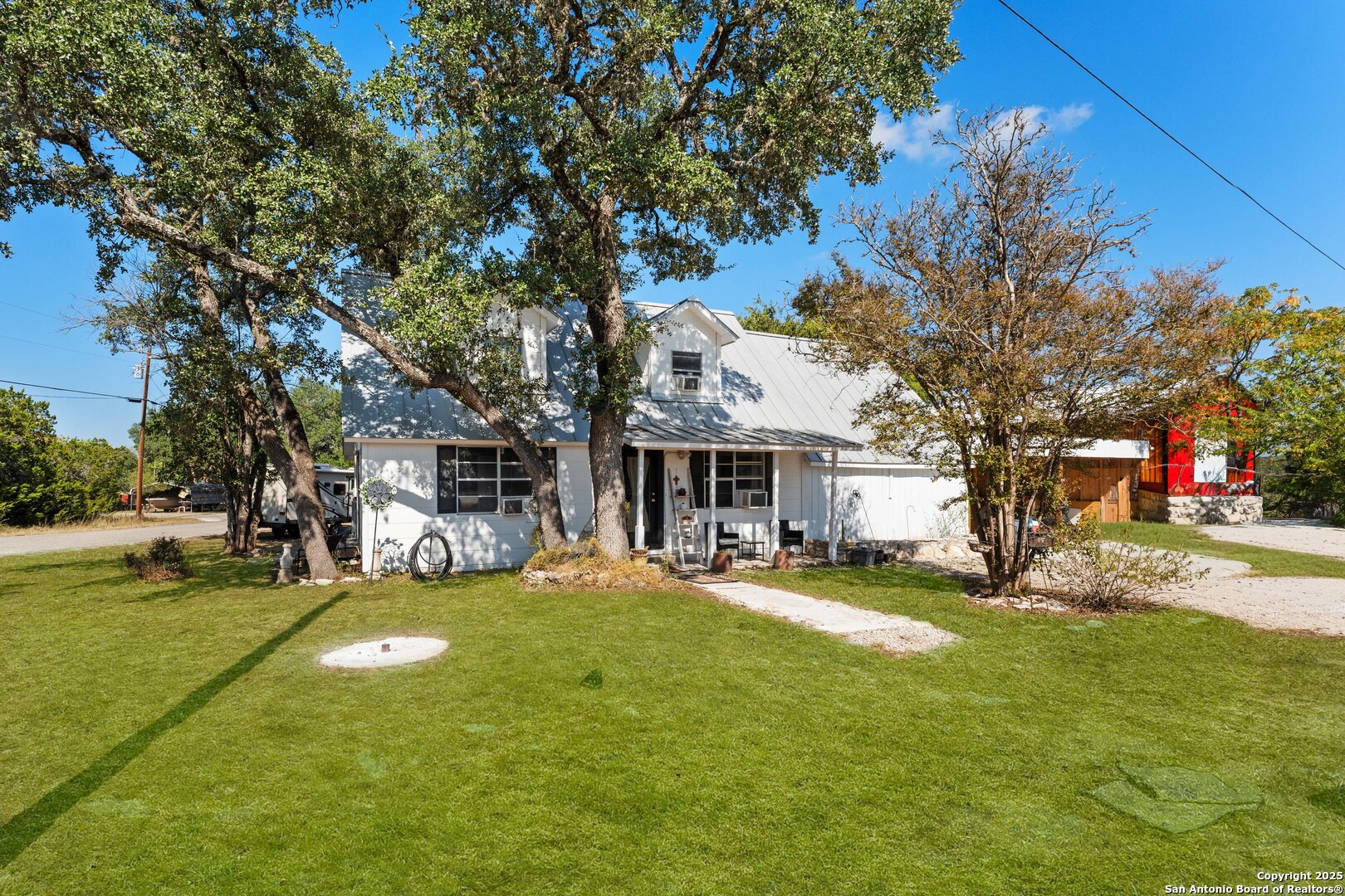 a view of a house with a big yard and large trees