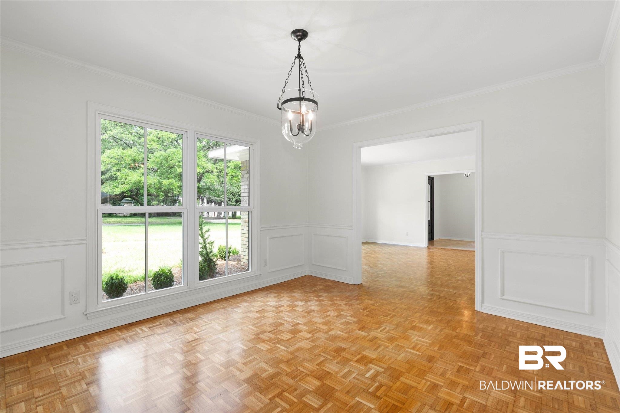 555 East Cumberland Road Mobile, AL 36608 - Photo 9 of 21 Empty room featuring crown molding, an inviting chandelier, wainscoting, and a decorative wall