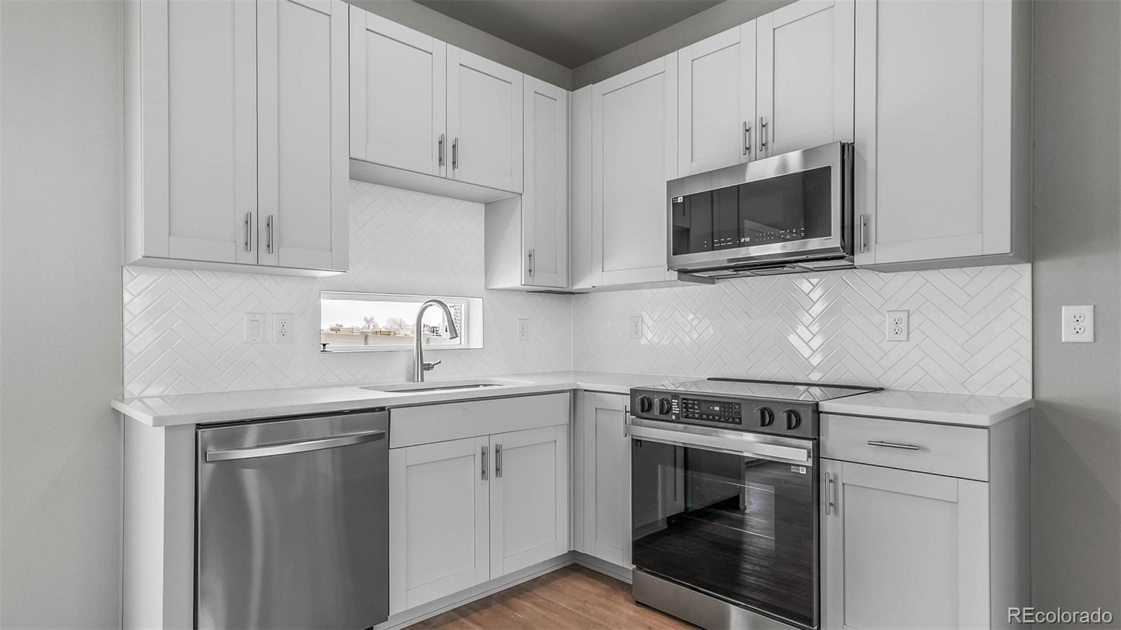 a kitchen with white cabinets stainless steel appliances and sink