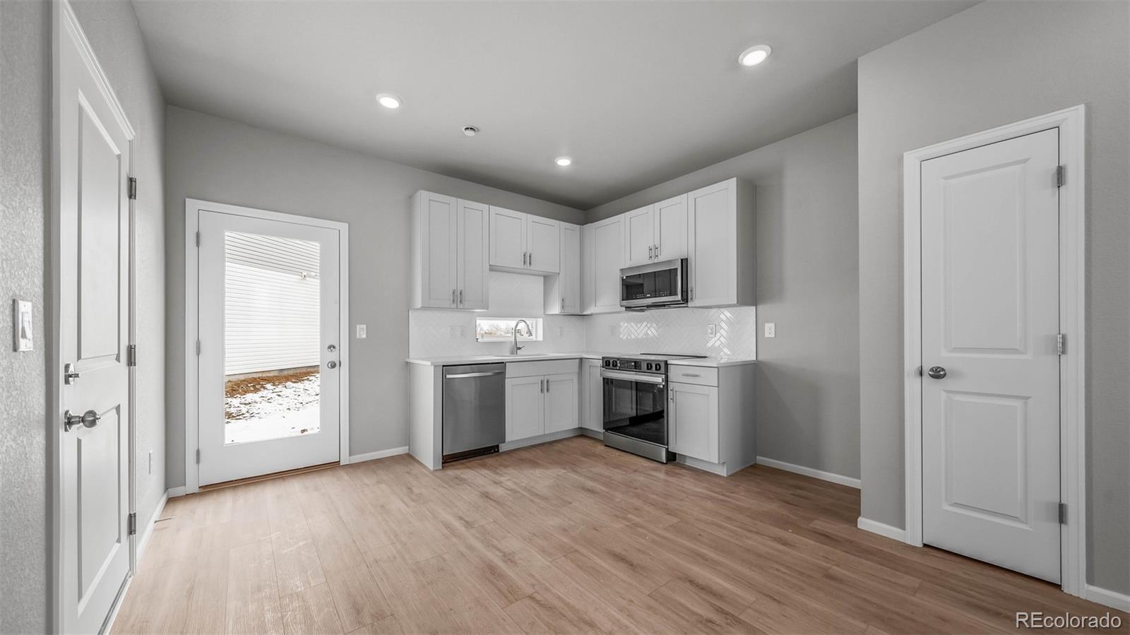 3970 North Rome Street Aurora, CO 80019 - Photo 3 of 22 a kitchen with a refrigerator and a stove top oven
