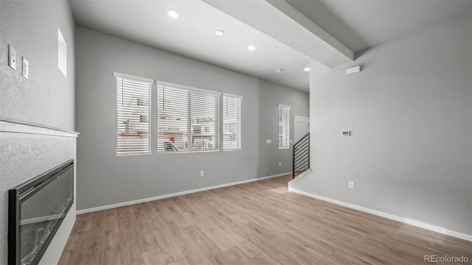 3970 North Rome Street Aurora, CO 80019 - Photo 6 of 22 an empty room with wooden floor and windows