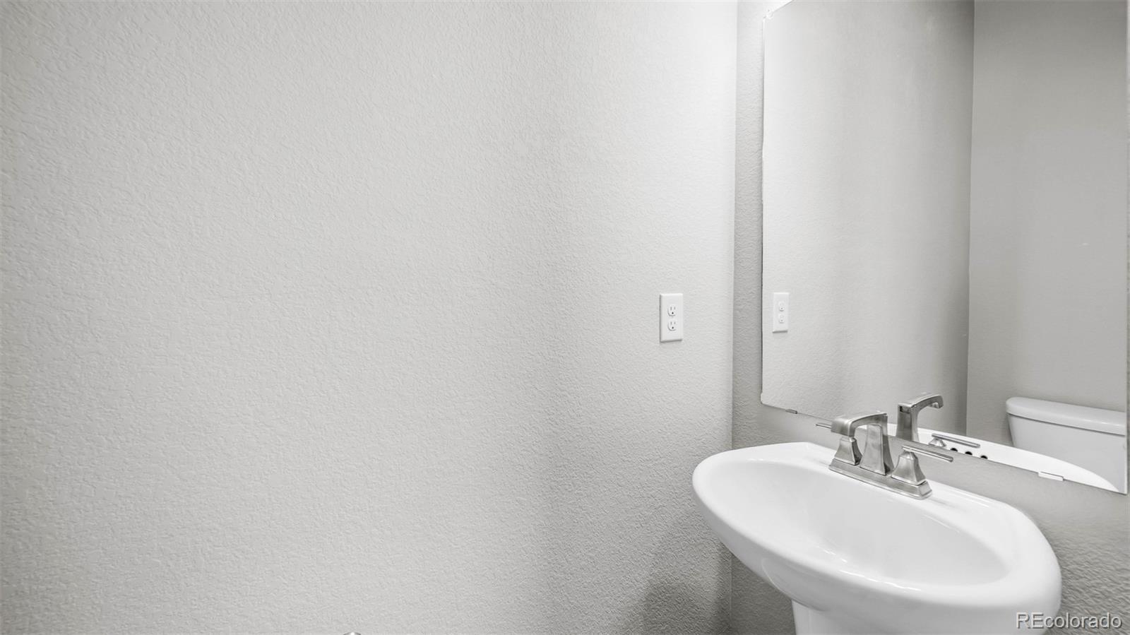 3970 North Rome Street Aurora, CO 80019 - Photo 10 of 22 a bathroom with a sink and a mirror