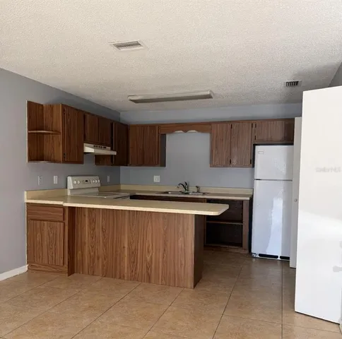 a kitchen with a refrigerator and a stove
