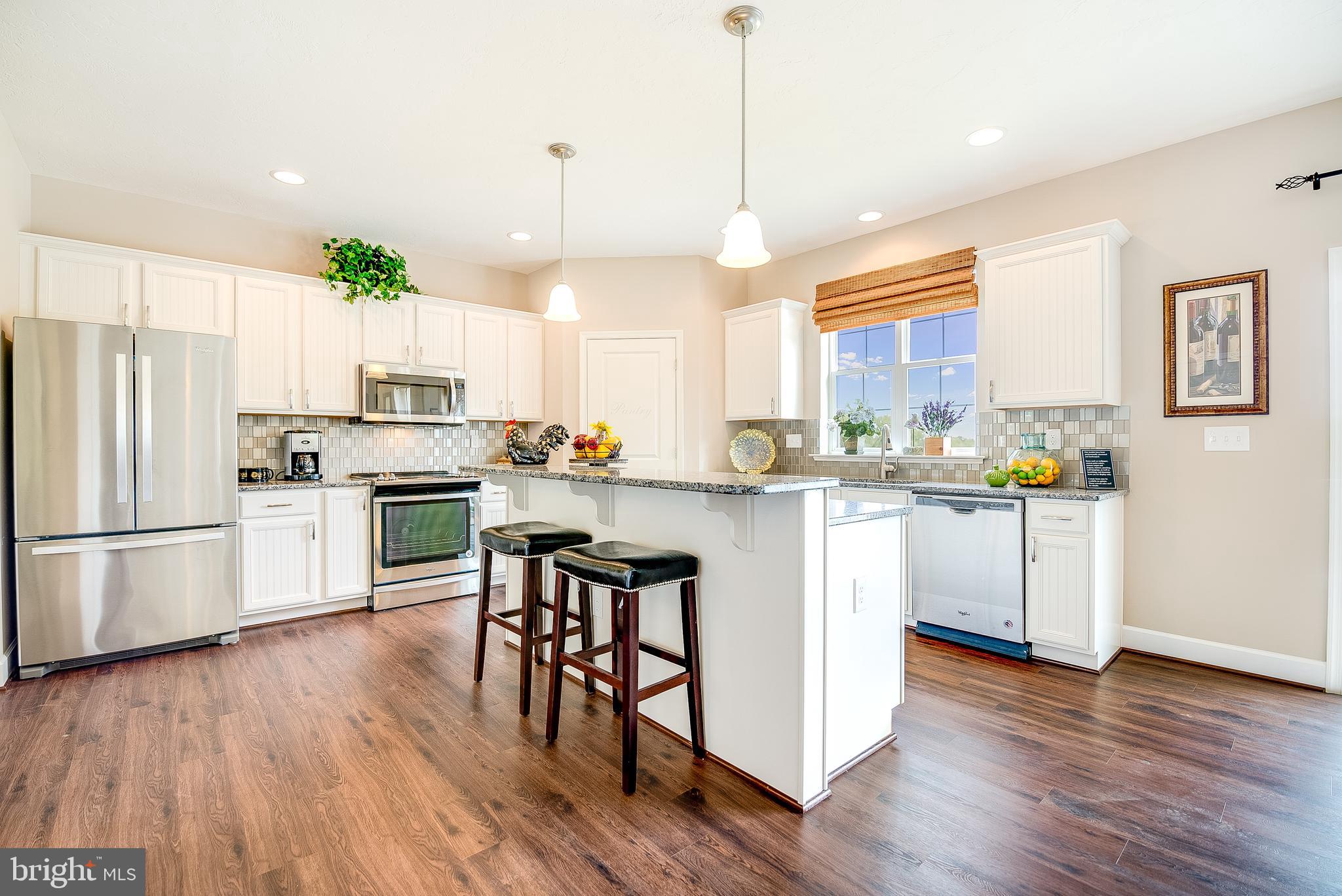 102 Piedmont Way, Unit 139 Hanover, PA 17331 - Photo 7 of 27 a kitchen with white cabinets stainless steel appliances and wooden floor