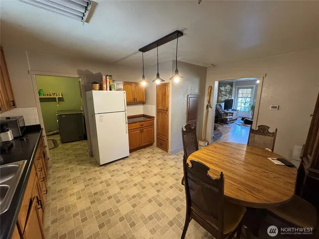 a kitchen with refrigerator and chairs