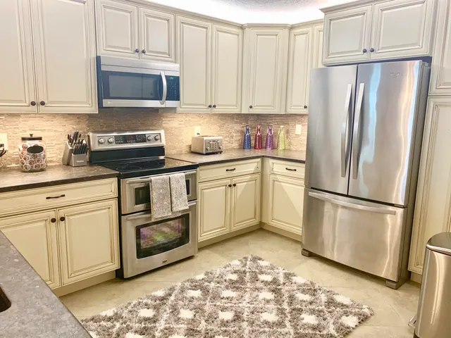 a kitchen with stainless steel appliances granite countertop a sink stove and cabinets