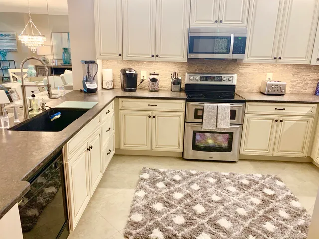a kitchen with sink refrigerator and microwave