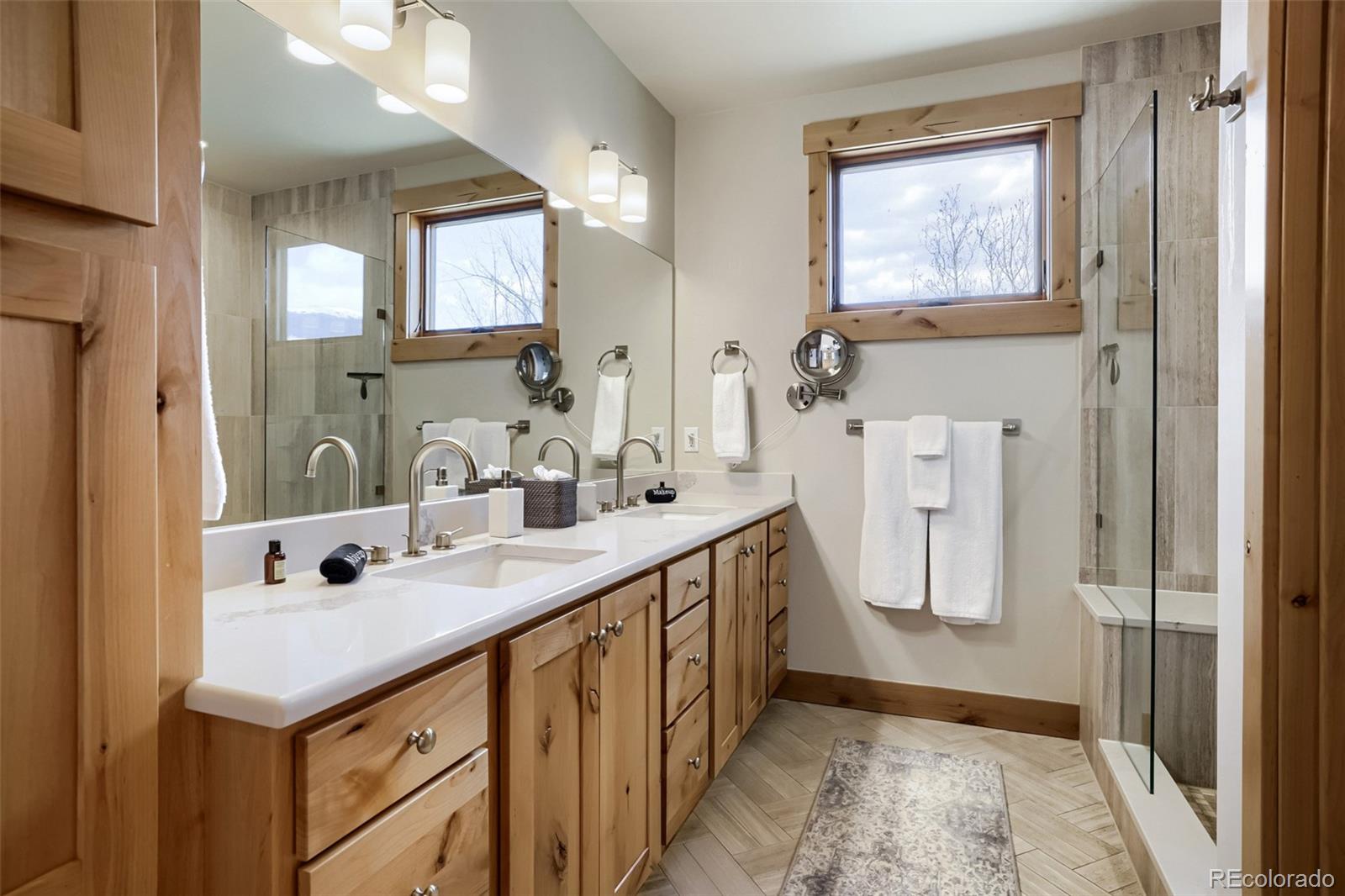 836 Maryland Creek Road Silverthorne, CO 80498 - Photo 21 of 49 a spacious bathroom with a double vanity sink a mirror and a shower