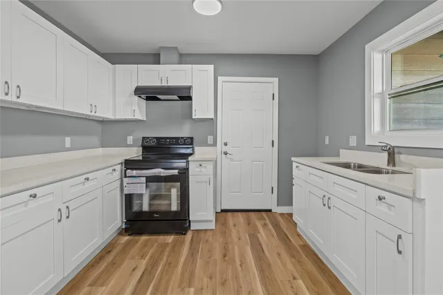 a kitchen with stainless steel appliances a stove sink and cabinets