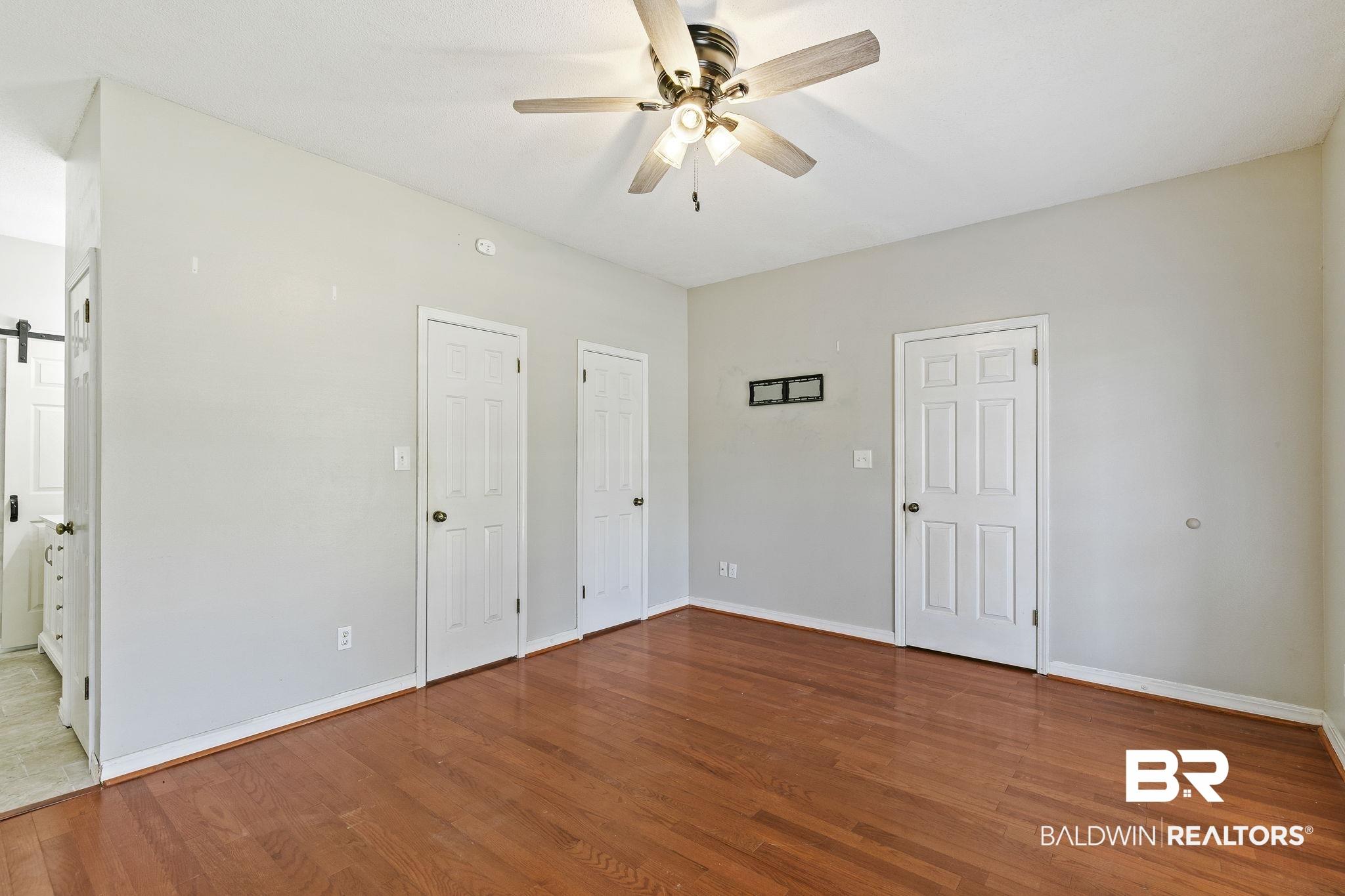 474 Ridgewood Drive Daphne, AL 36526 - Photo 29 of 57 Unfurnished bedroom with multiple closets, hardwood / wood-style flooring, and ceiling fan