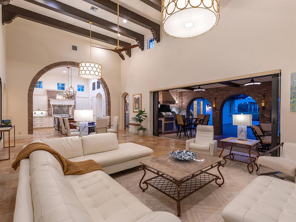 7951 Matera Court Lakewood Ranch, FL 34202 - Photo 16 of 81 a living room with furniture a rug and a chandelier