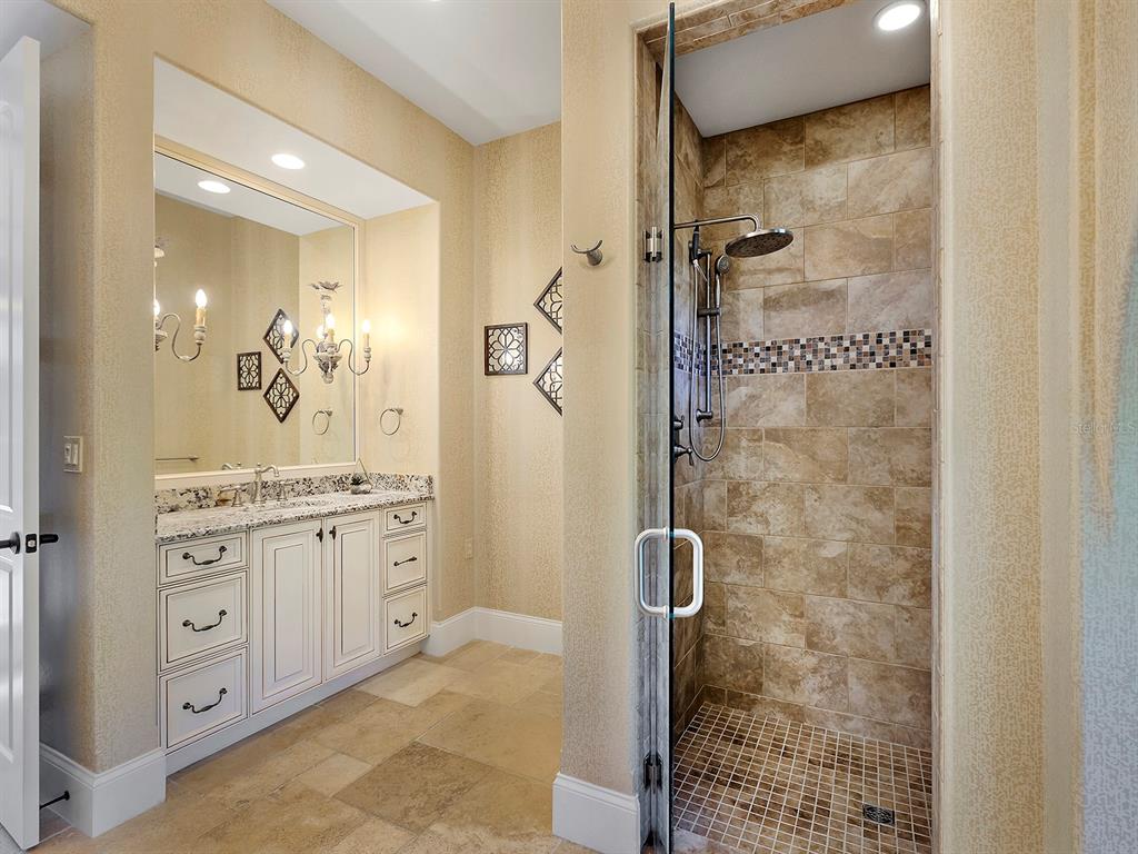 7951 Matera Court Lakewood Ranch, FL 34202 - Photo 32 of 81 a bathroom with a granite countertop shower sink vanity and mirror