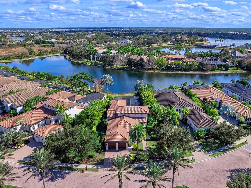 7951 Matera Court Lakewood Ranch, FL 34202 - Photo 4 of 81 an aerial view of a house with a garden and lake view