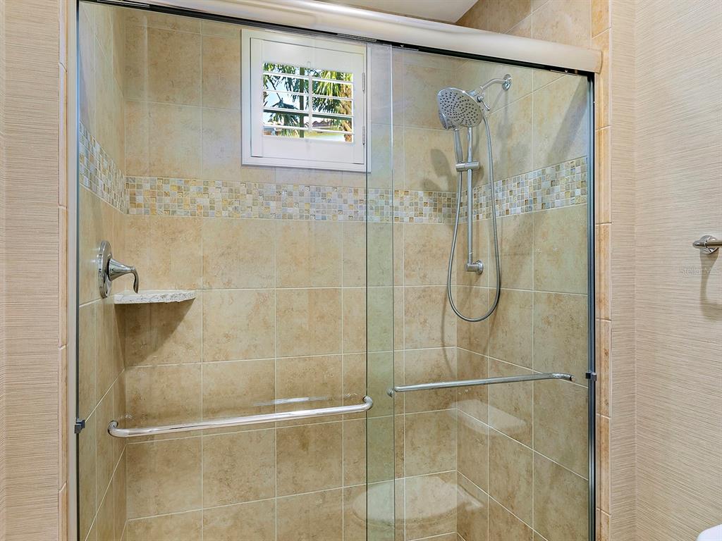 7951 Matera Court Lakewood Ranch, FL 34202 - Photo 43 of 81 a bathroom with a glass shower door