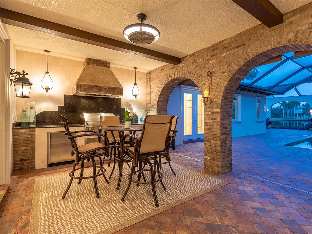 7951 Matera Court Lakewood Ranch, FL 34202 - Photo 50 of 81 a view of a dining room with furniture a chandelier and wooden floor