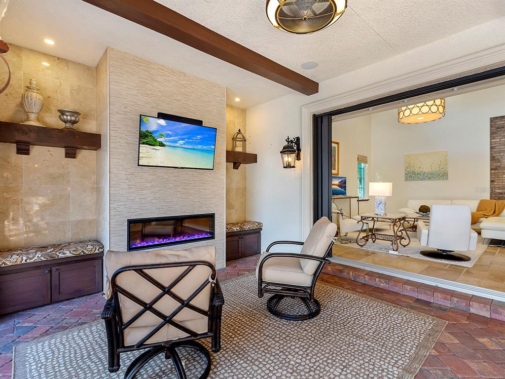 7951 Matera Court Lakewood Ranch, FL 34202 - Photo 51 of 81 a living room with furniture a rug and a fireplace