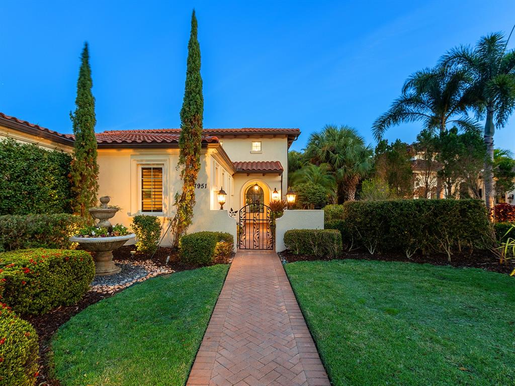 7951 Matera Court Lakewood Ranch, FL 34202 - Photo 8 of 81 a front view of a house with a yard and potted plants
