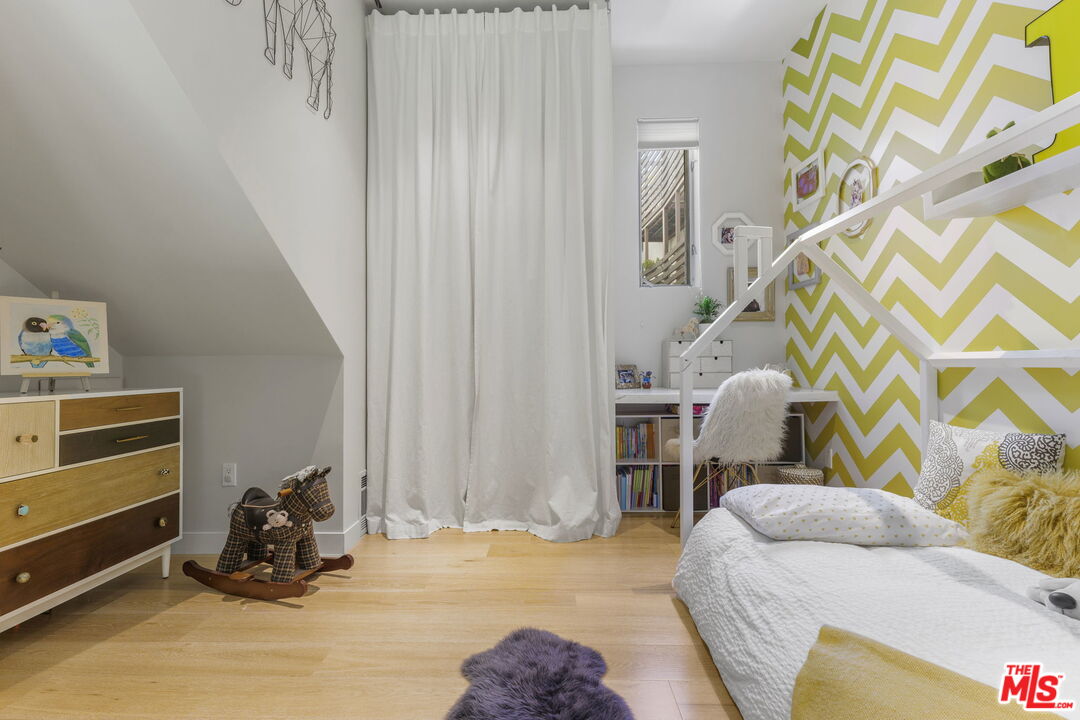 123 North Kings Road, Unit 11 Los Angeles, CA 90048 - Photo 20 of 27 a bedroom with a bed and a chandelier