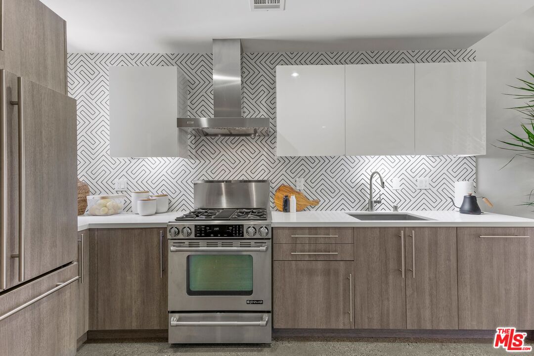 123 North Kings Road, Unit 11 Los Angeles, CA 90048 - Photo 9 of 27 a kitchen with granite countertop a stove and a wooden cabinets