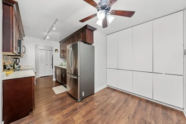 a kitchen with stainless steel appliances a refrigerator and a chandelier